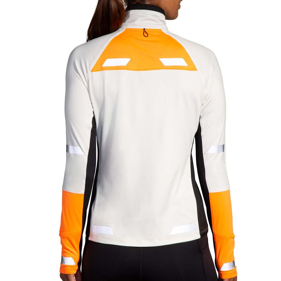 Back view of a model wearing the Brooks Women's Run Visible 1/2 Zip 2.0 in the Ecru/Fluoro Flash/Black colourway. Model is also wearing Brooks tights. (8499447333026)
