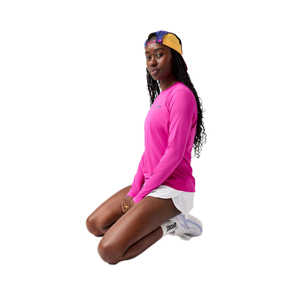 Angled view of a model wearing the Brooks Women's Sprint Free Long Sleeve 3.0 in the Magenta colourway. (8718900986018)