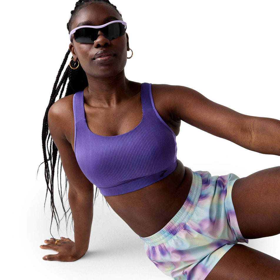Angled view of a model wearing the Brooks Women's Dash Short in the Euphoryc Halogen colourway.