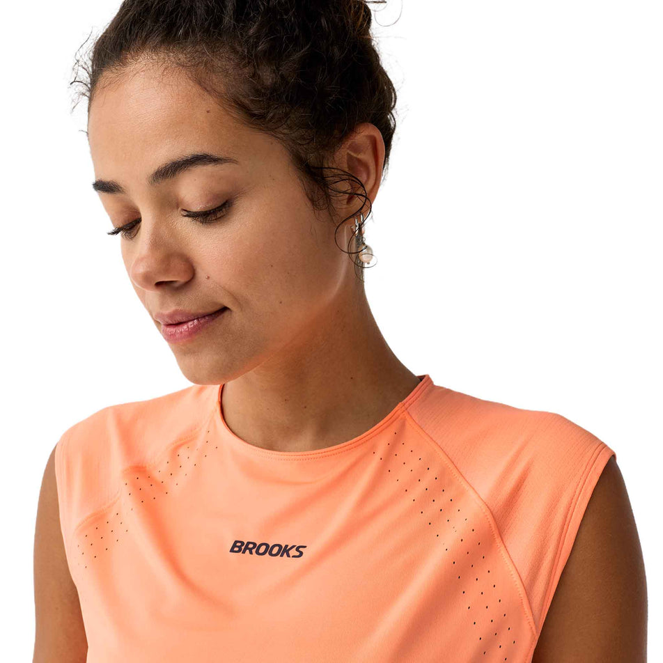 Front view of a model wearing the Brooks Women's Dash Cooling Short Sleeve in the Cyber Peach colourway.