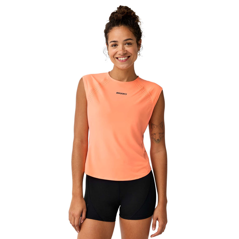 Front view of a model wearing the Brooks Women's Dash Cooling Short Sleeve in the Cyber Peach colourway.