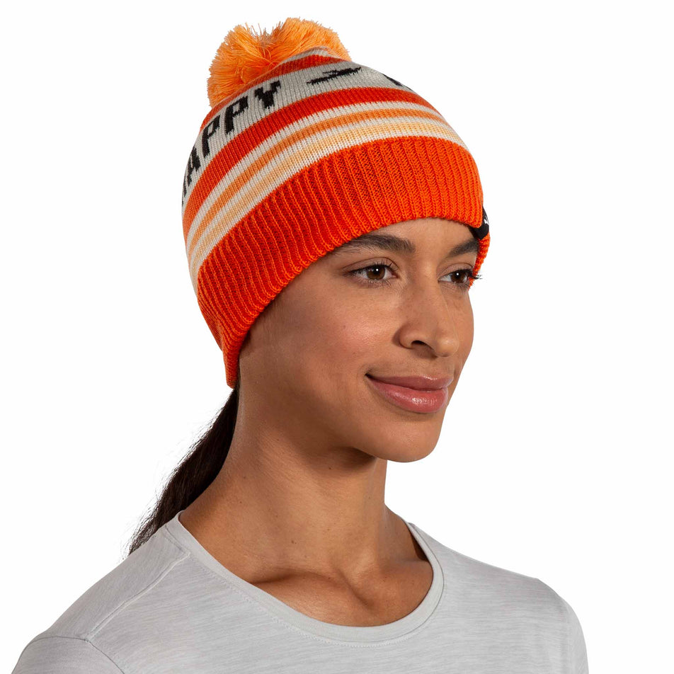 Front view of a model wearing the Brooks Unisex Heritage Pom Beanie in the Fluoro Flash Run Happy colourway. (8511194333346)