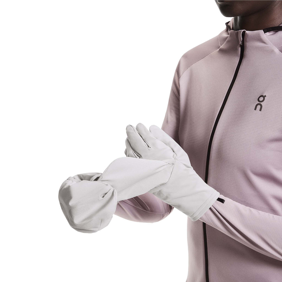 A model demonstrating the 2-in-1 design of the On Core Glove in the Alloy colourway.