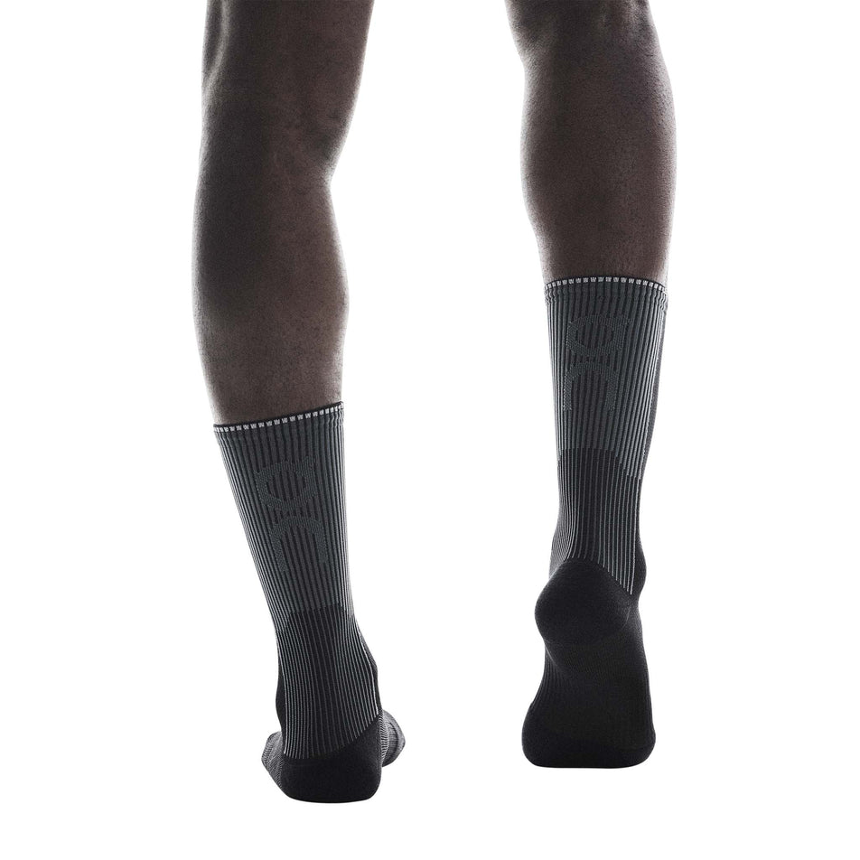Back view of a model wearing a pair of On Unisex Performance Run Sock High in the Black/Eclipse colourway.