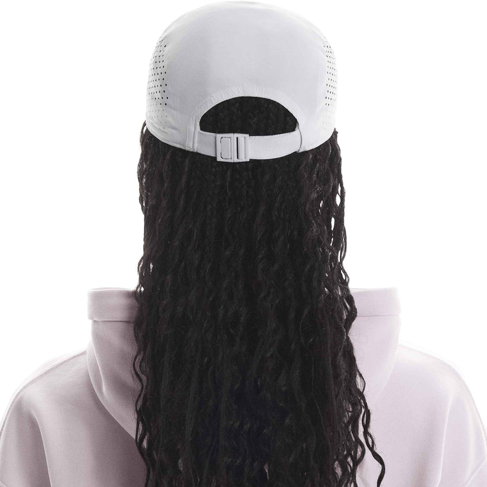 Back view of a model wearing the On Unisex Lightweight Cap in the White colourway. (8717292404898)