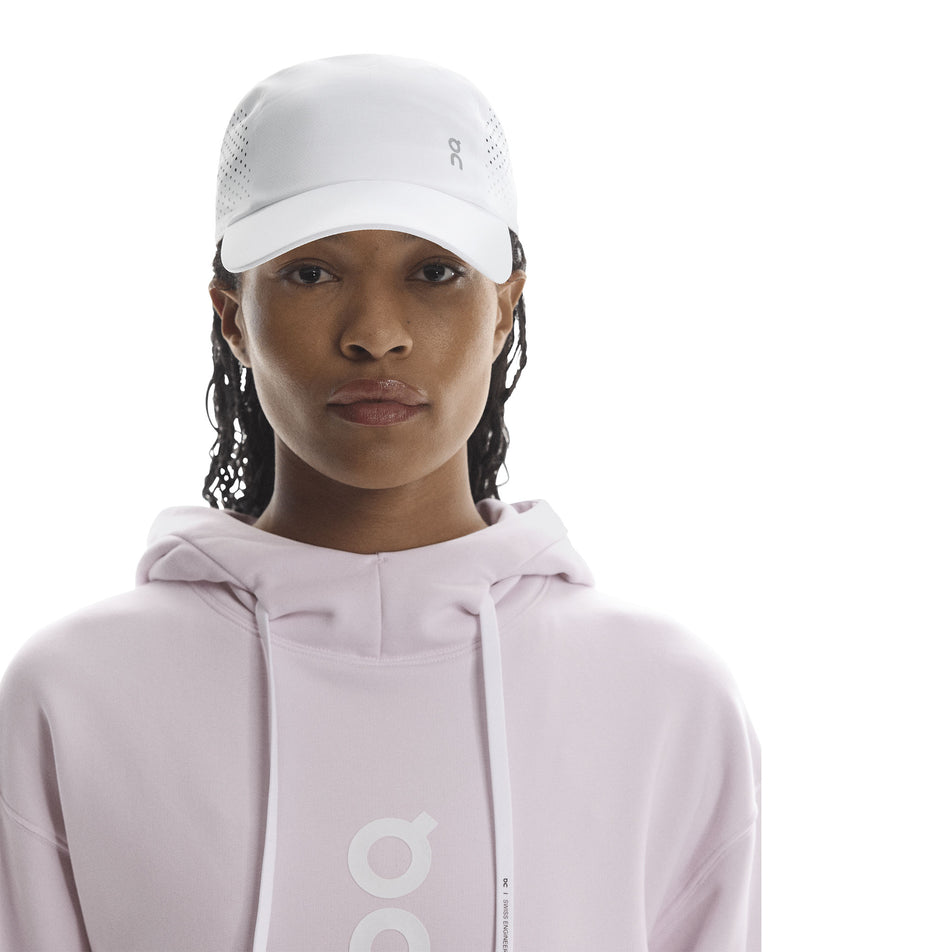 Front view of a model wearing the On Unisex Lightweight Cap in the White colourway. (8717292404898)