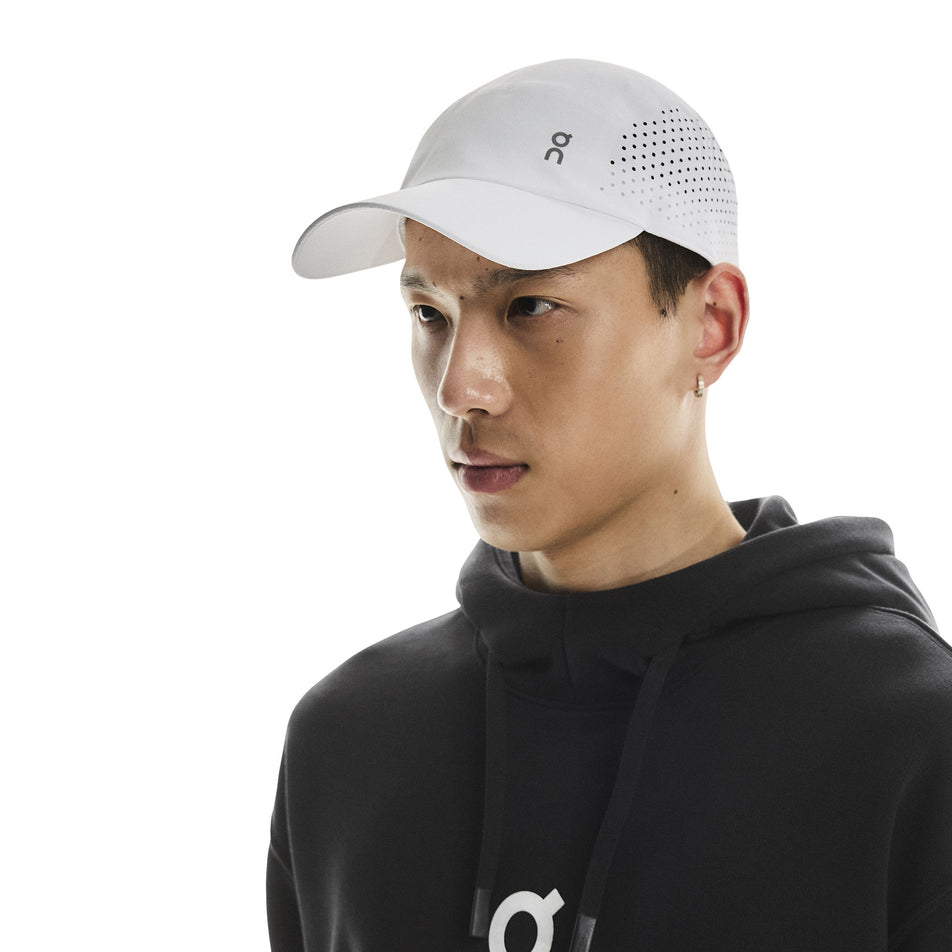 Angled view of a model wearing the On Unisex Lightweight Cap in the White colourway. (8717292404898)