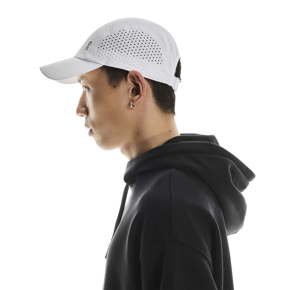 Side view of a model wearing the On Unisex Lightweight Cap in the White colourway. (8717292404898)