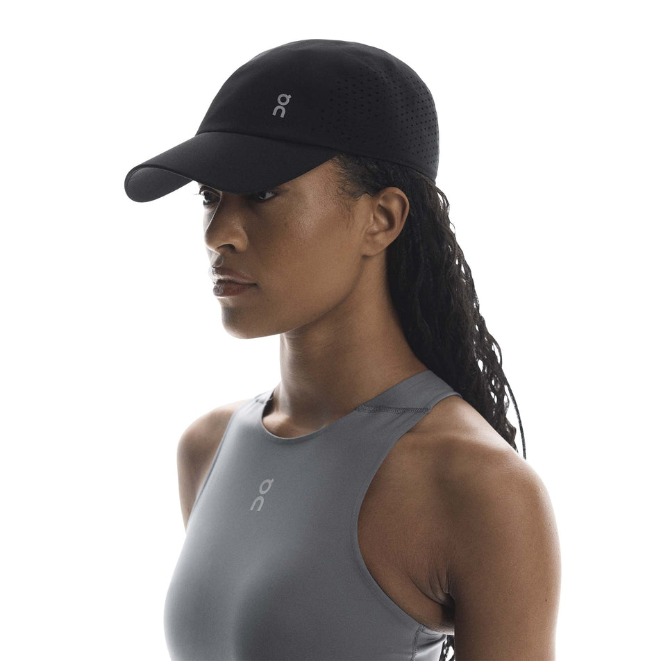 Front view of a model wearing the On Unisex Lightweight Cap in the Black colourway.