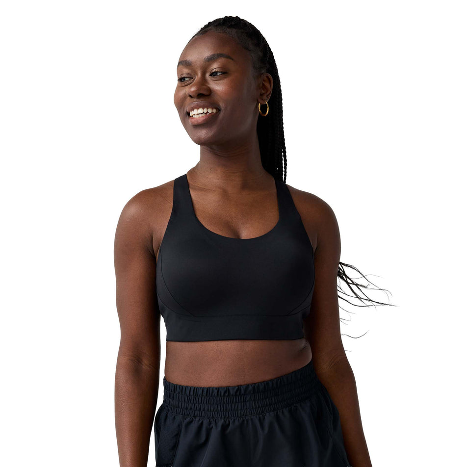 Front view of a model wearing the Brooks Women's Limitless Racer Bra in the Black colourway.