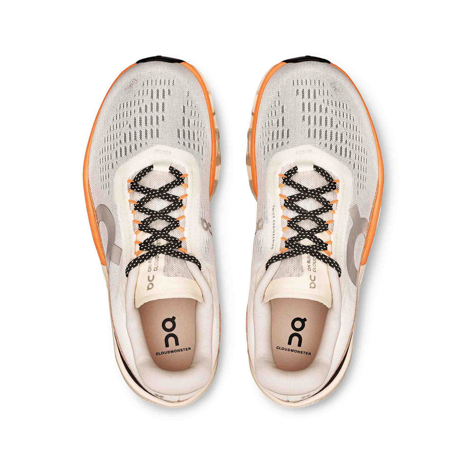 The uppers of a pair of On Women's Cloudmonster 2 Running Shoes in the Ivory/Tangerine colourway. (8714534453410)
