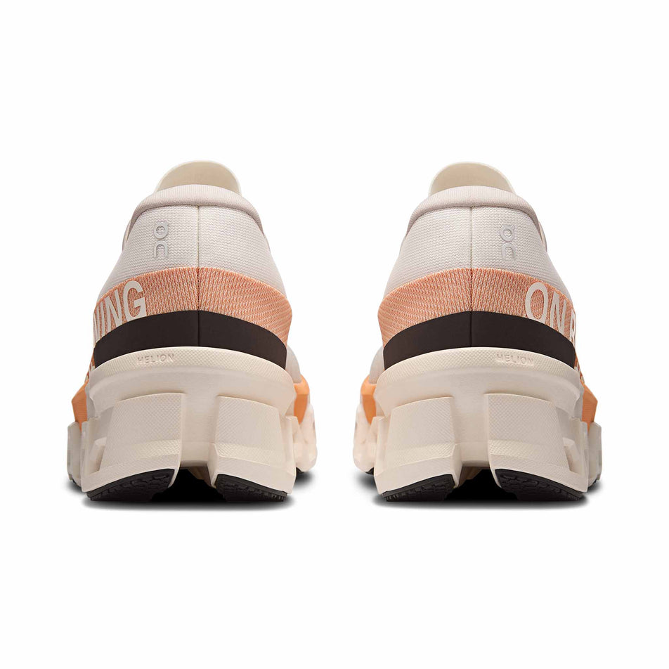 The back of a pair of On Women's Cloudmonster 2 Running Shoes in the Ivory/Tangerine colourway. (8714534453410)