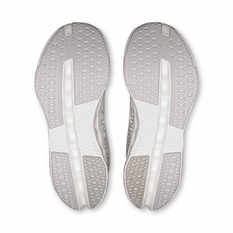 The outsoles of a pair of On Women's Cloudsurfer Next Running Shoes in the White/White colourway.