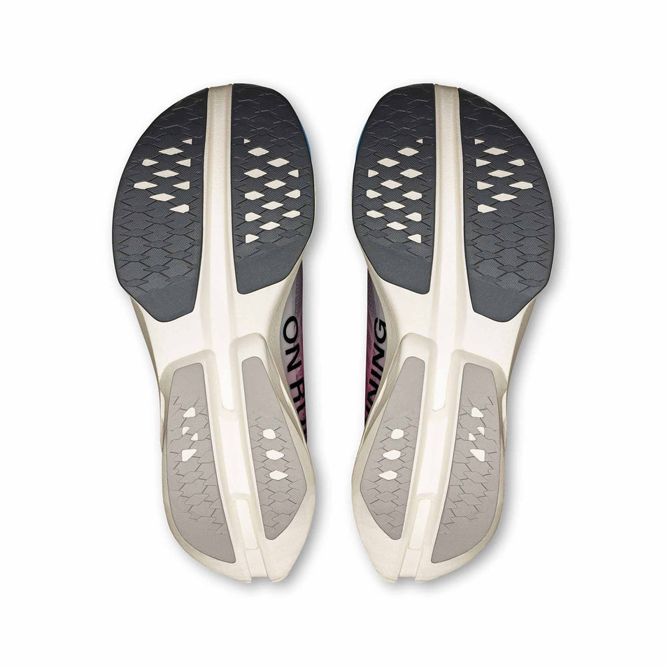The outsoles of a pair of On Women's Cloudboom Strike Running Shoes in the White/Horizon colourway. (8714514890914)
