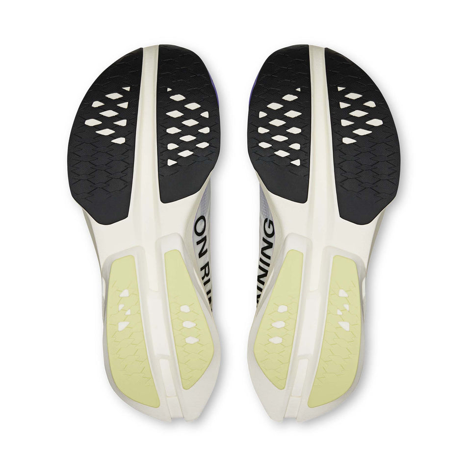 The outsoles of a pair of On Women's Cloudboom Strike Running Shoes in the Juniper/Limelight colourway.