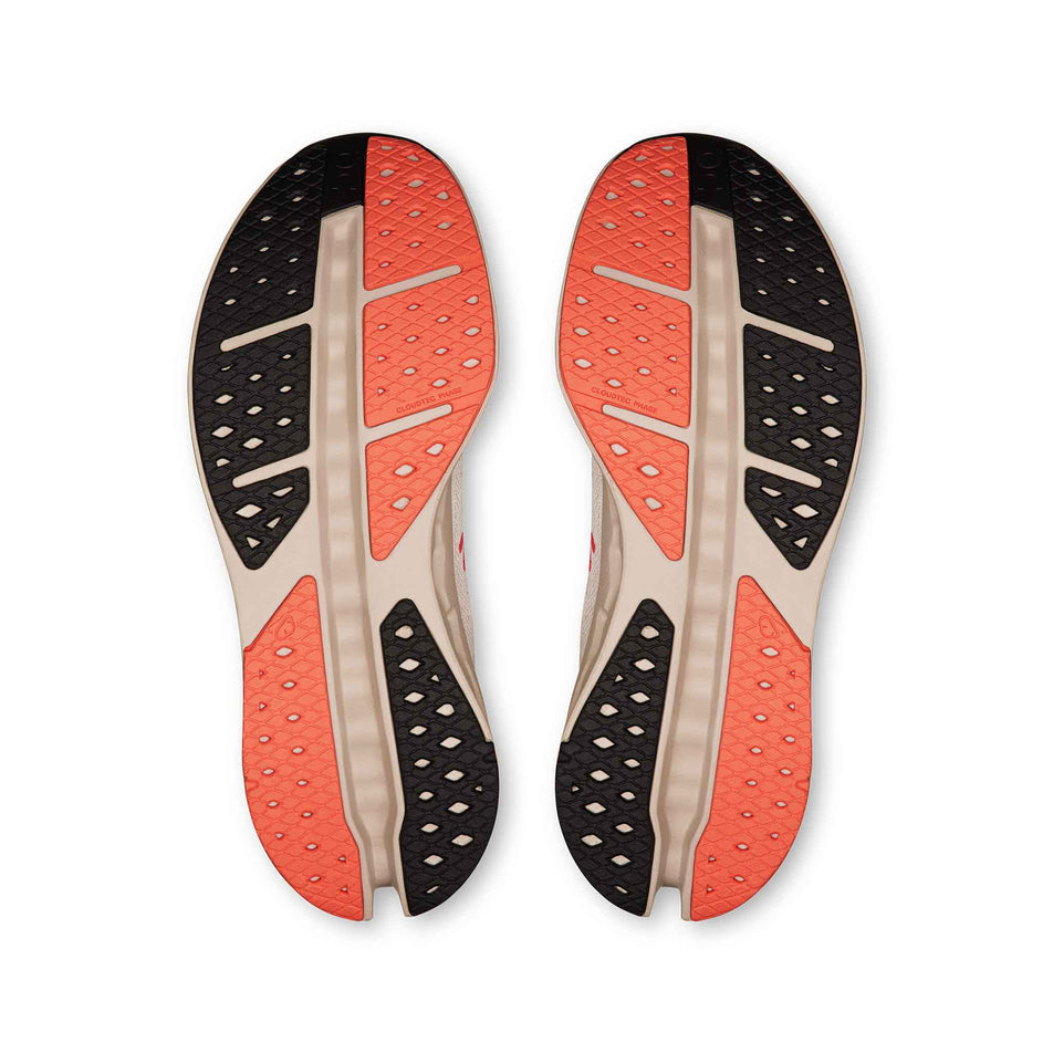 The outsoles of a pair of On Women's Cloudsurfer Max Running Shoes in the Ivory/Salmon colourway. (8714533634210)