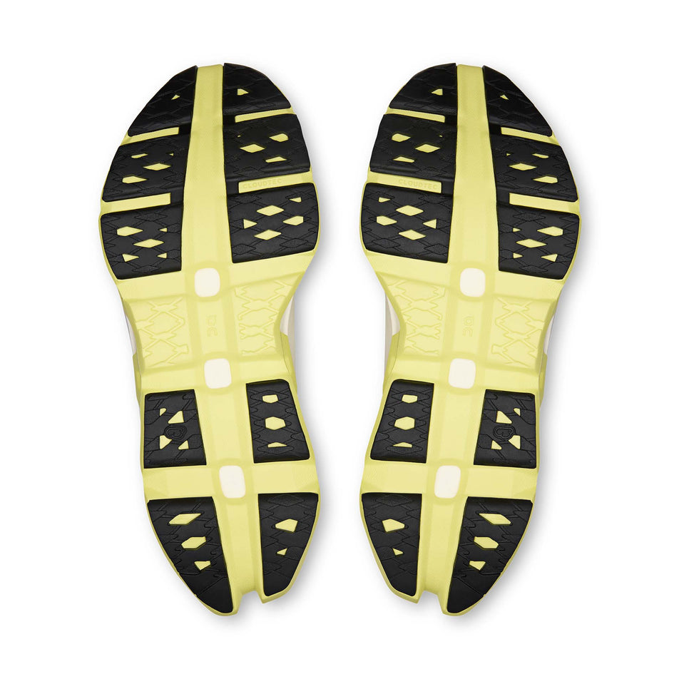 The outsoles of a pair of On Women's Cloudmonster 3 Hyper Running Shoes in the Lily/Limelight colourway.