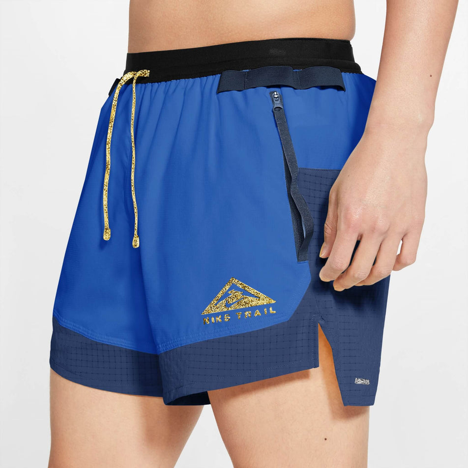 Angled front view of a model wearing a pair of Nike Men's Dri-FIT Flex Stride Trail Shorts in the Hyper Royal/Midnight Navy/Citron Pulse colourway  (8140183535778)