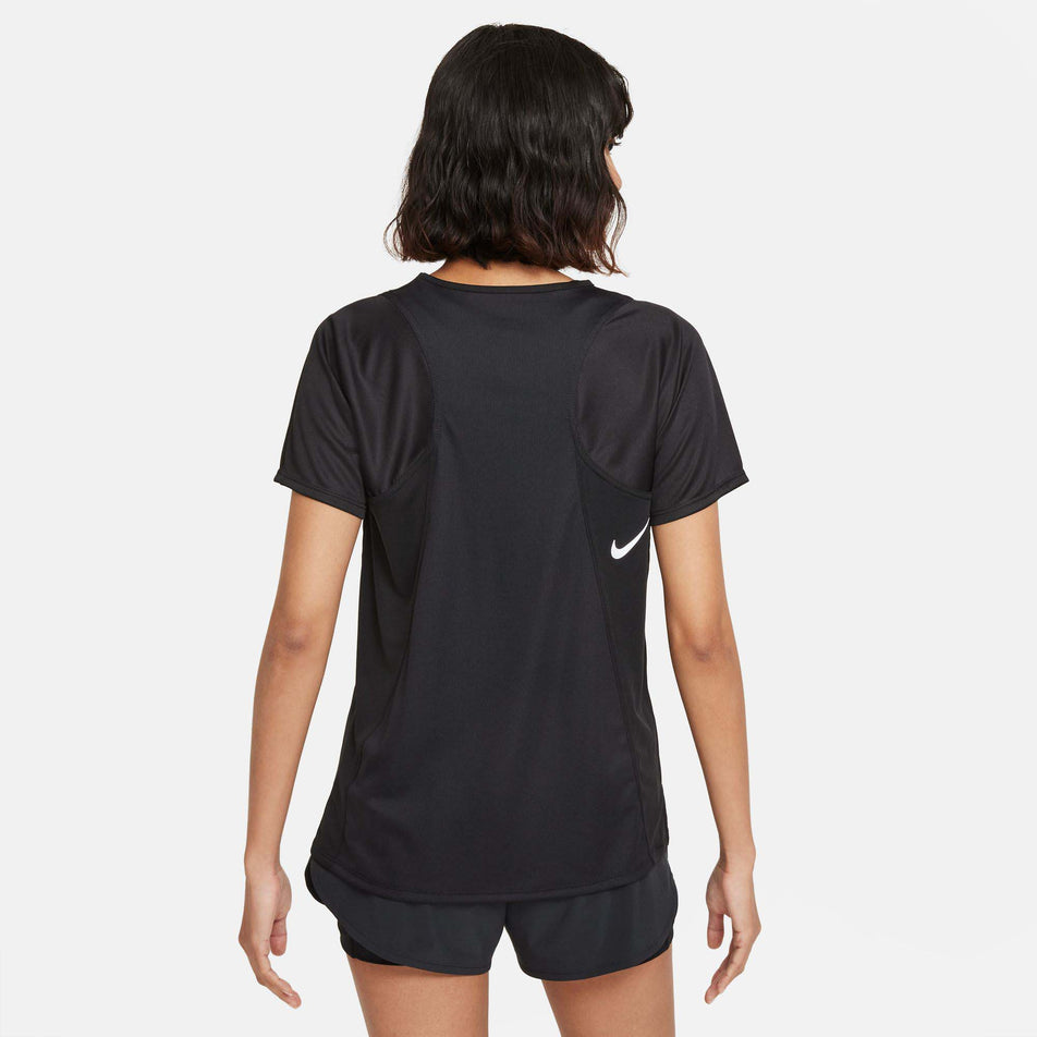 Back view of a model wearing a Nike Women's Dri-FIT Race Short-Sleeve Running Top in the Black/Reflective Silv colourway. Model is also wearing black Nike shorts. (8215857397922)