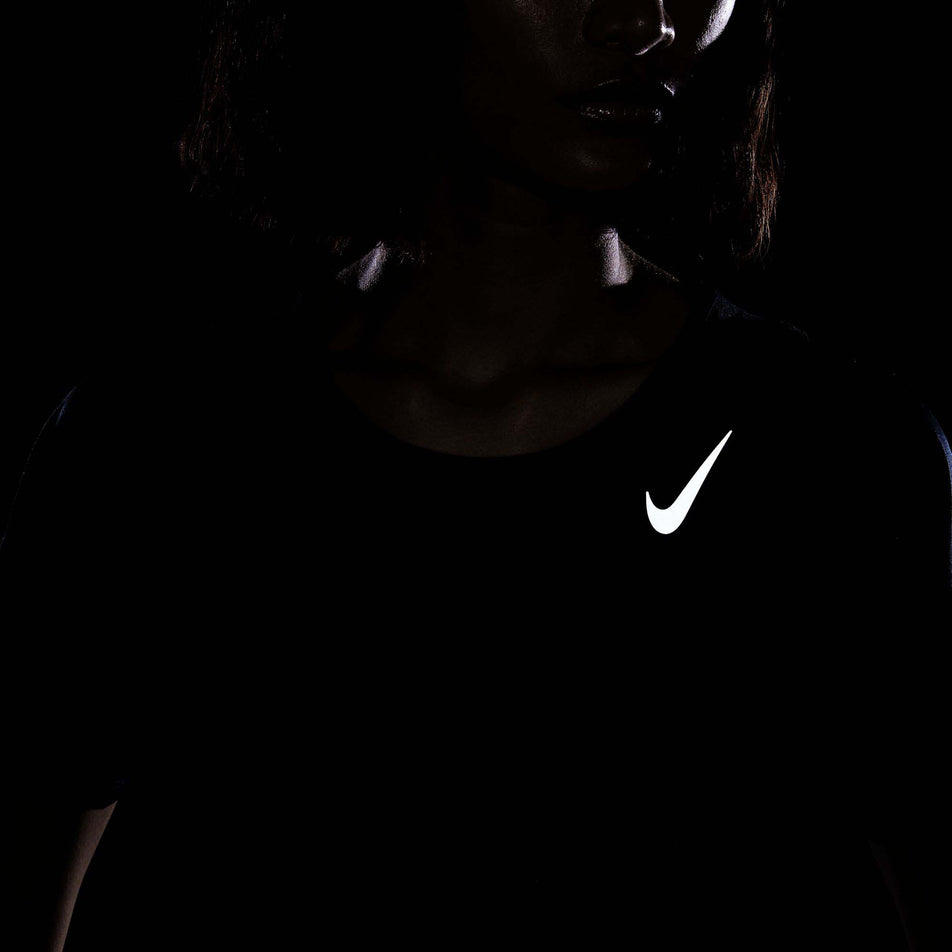 The reflective Swoosh on the front of a Nike Women's Dri-FIT Race Short-Sleeve Running Top in the Black/Reflective Silv colourway.  (8215857397922)