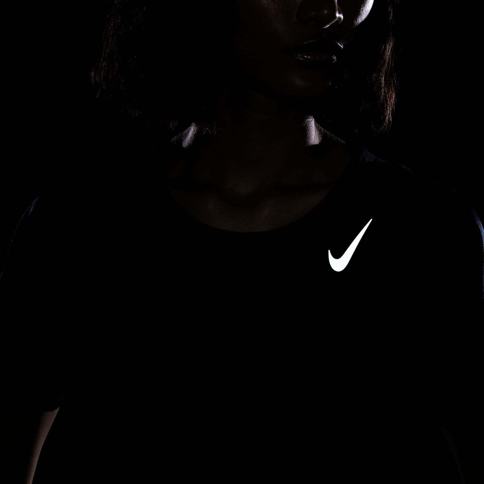 The reflective Swoosh on the front of a Nike Women's Dri-FIT Race Short-Sleeve Running Top in the Black/Reflective Silv colourway. (8215857397922)