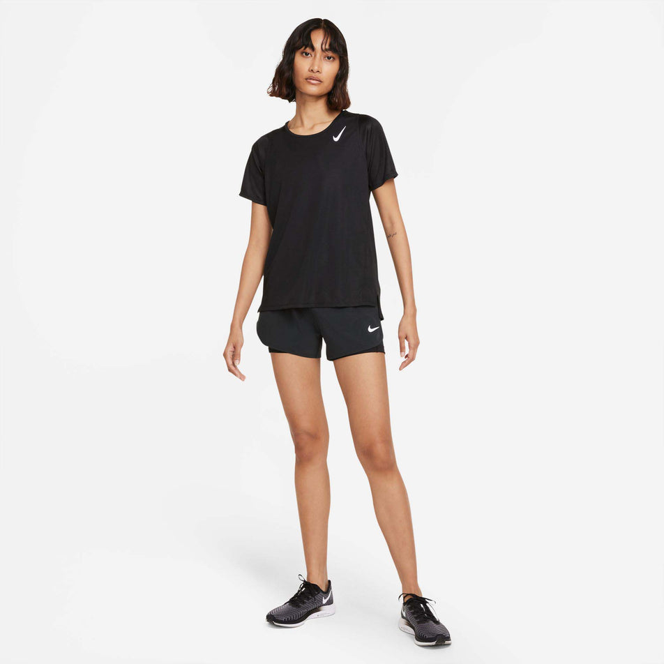 Front view of a model wearing a Nike Women's Dri-FIT Race Short-Sleeve Running Top in the Black/Reflective Silv colourway. Model is also wearing Nike shoes and black Nike shorts. (8215857397922)