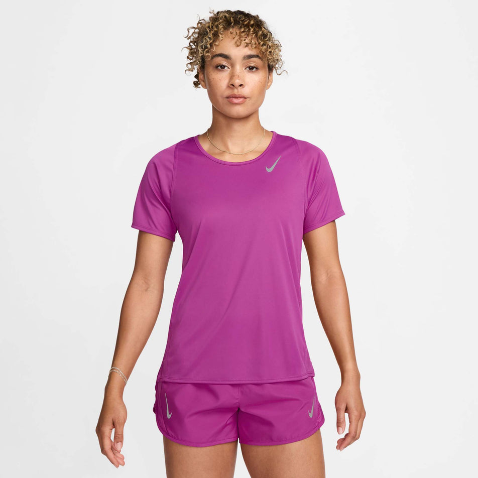 Front view of a model wearing a Nike Women's Dri-FIT Race Short-Sleeve Running Top in the Hot Fuchsia/Reflective Silv colourway. Model is also wearing Nike shorts. (8399187640482)