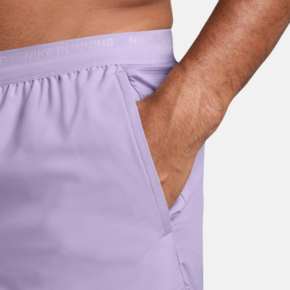 A model demonstrating the hand pocket on the left side of the Nike Men's Dri-FIT Stride 5