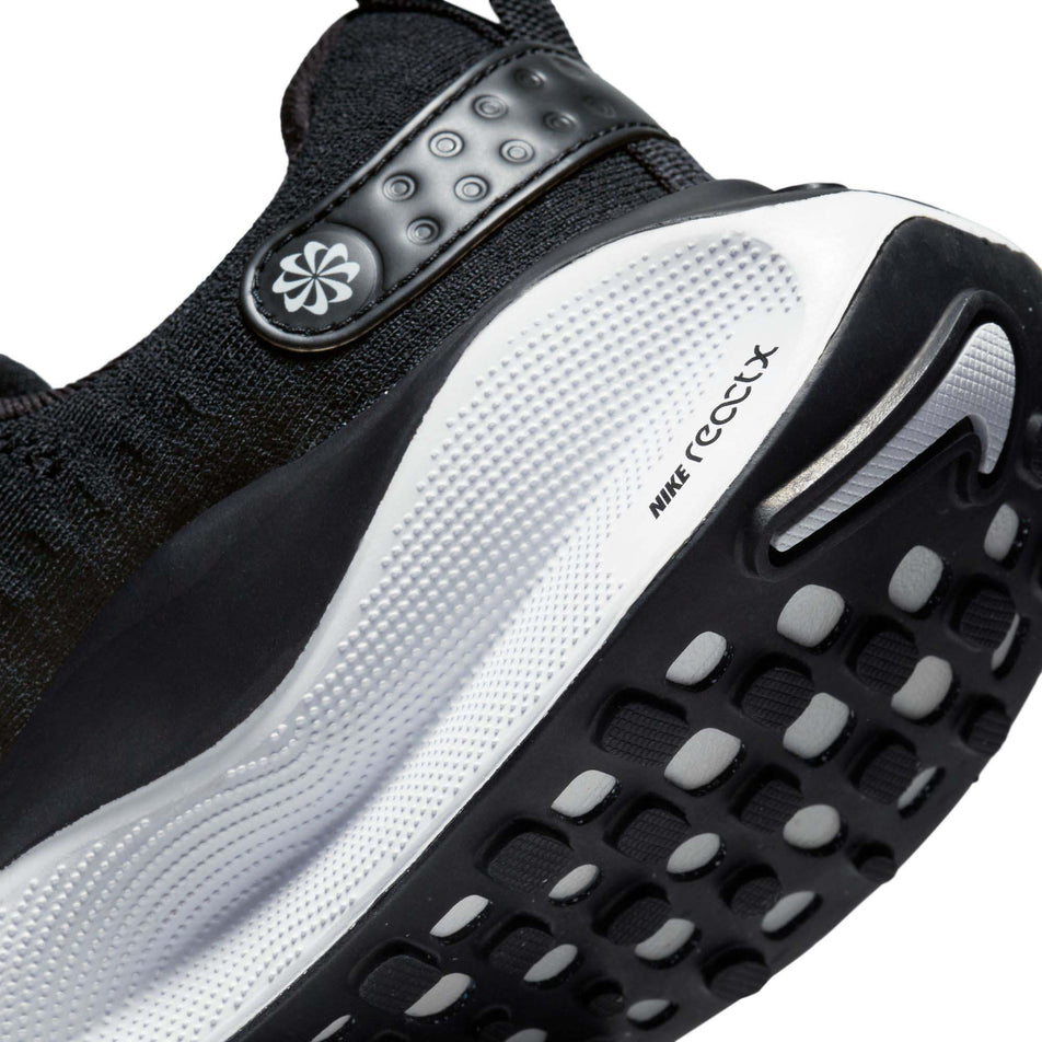Lateral side of the back of the left shoe from a pair of Nike Women's Infinity RN 4 Road Running Shoes in the Black/White-Dark Grey colourway (7979380277410)