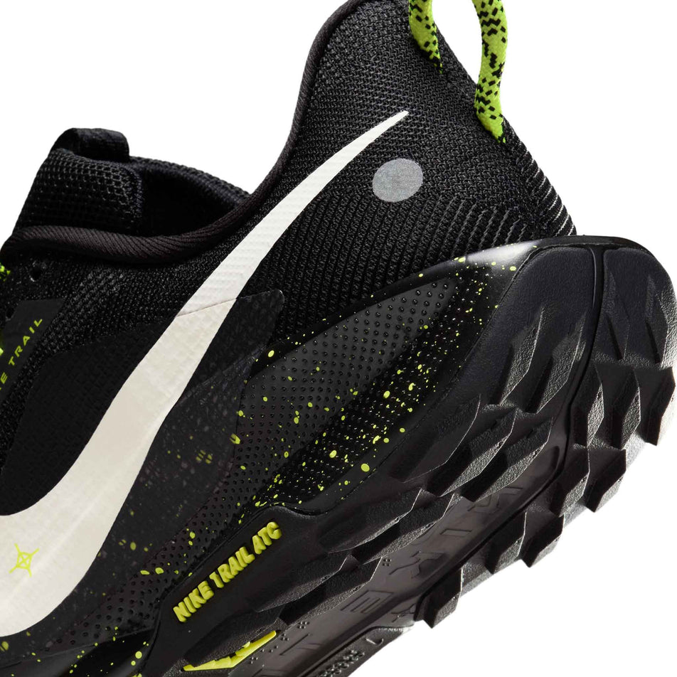 Close-up view of the rearfoot section of the left shoe from a pair of Nike Women's Pegasus Trail 5 Running Shoes in the Black/Phantom-Volt Ice colourway.
