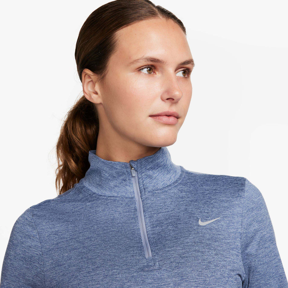 The upper body front section of a Nike Women's Dri-FIT Swift Element UV 1/4-Zip Running Top in the Ashen Slate/Reflective Silv colourway. The top is being worn by a model. (8059808710818)