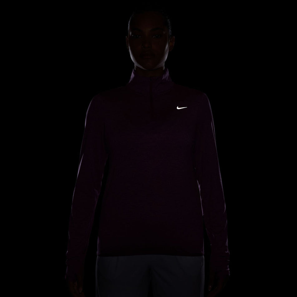 The reflective Swoosh on the Nike Women's Swift Element UV Protection 1/4-Zip Running Top in the Hot Fuchsia/Plum Dust/Reflective Silv colourway. (8497624383650)