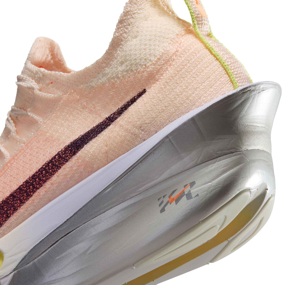 Close-up view of the rearfoot section of the left shoe from a pair of Nike Women's Alphafly 3 Road Racing Shoes in the Chalk/Purple Dynasty-Hyper Crimson colourway.