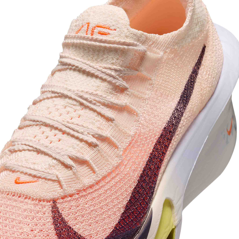 Close-up view of the upper of the left shoe from a pair of Nike Women's Alphafly 3 Road Racing Shoes in the Chalk/Purple Dynasty-Hyper Crimson colourway.