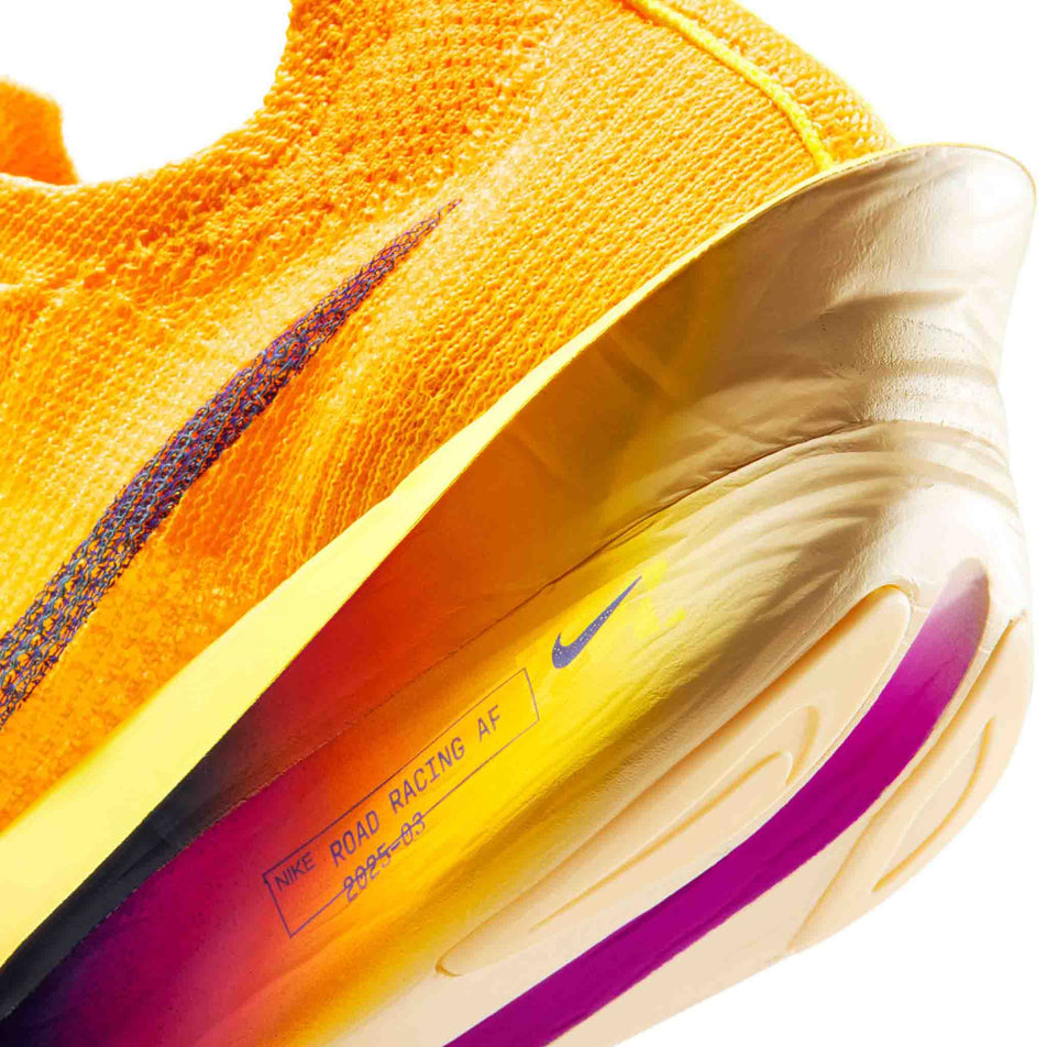 Close-up view of the rearfoot section of the left shoe from a pair of Nike Women's Alphafly 3 Road Racing Shoes in the Laser Orange/Indigo Burst-Citron Pulse colourway.