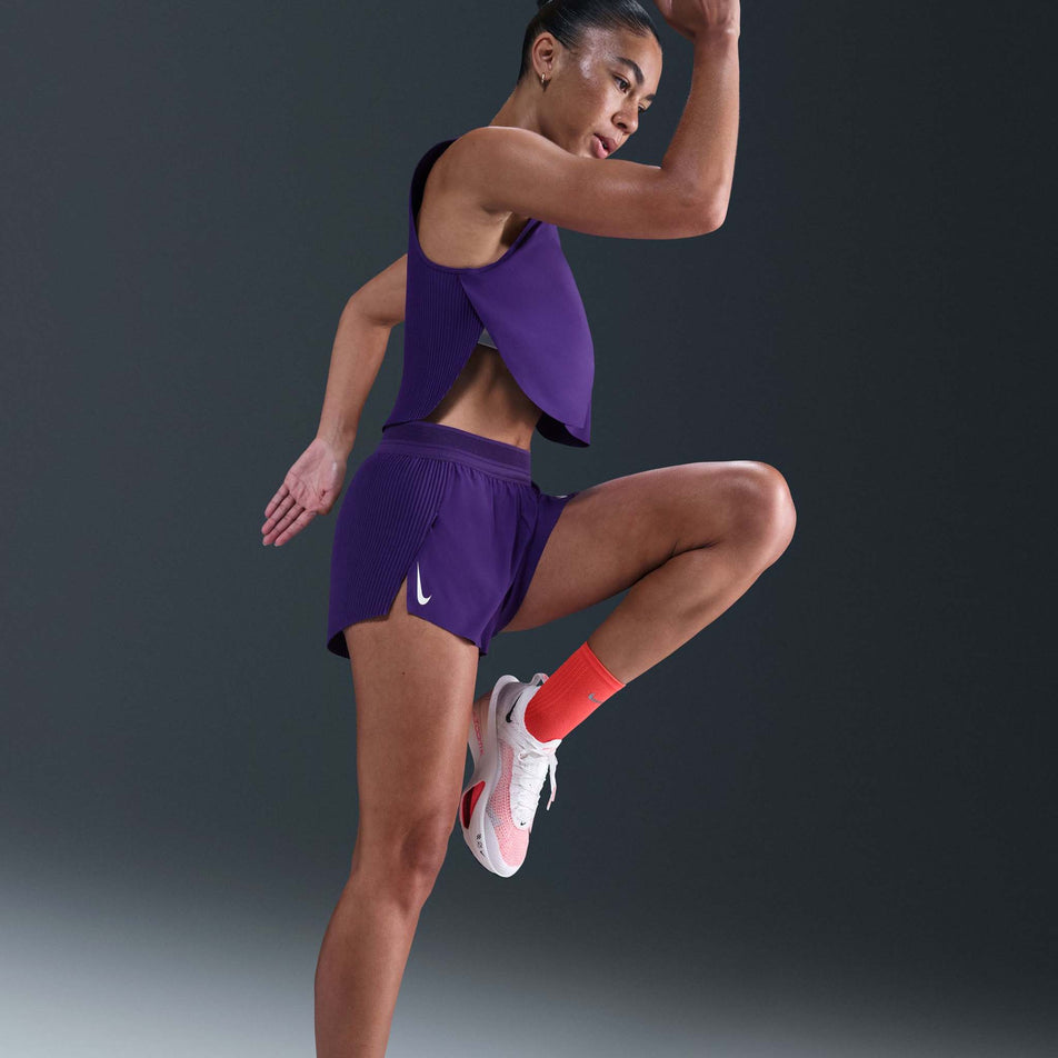 Side view of a model wearing the Nike Women's AeroSwift Dri-FIT ADV Mid-Rise Brief-Lined 3