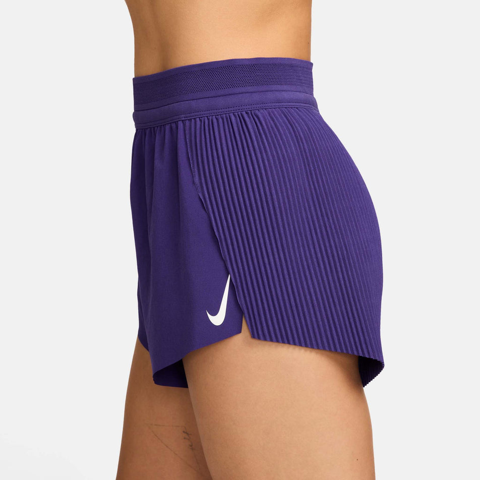 Side view of a model wearing the Nike Women's AeroSwift Dri-FIT ADV Mid-Rise Brief-Lined 3