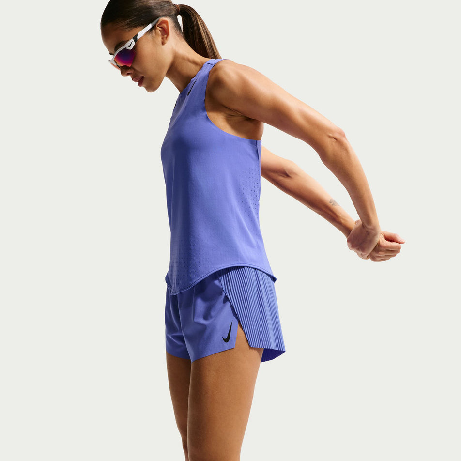 Side view of a model wearing the Nike Women's AeroSwift Dri-FIT ADV Mid-Rise Brief-Lined 3