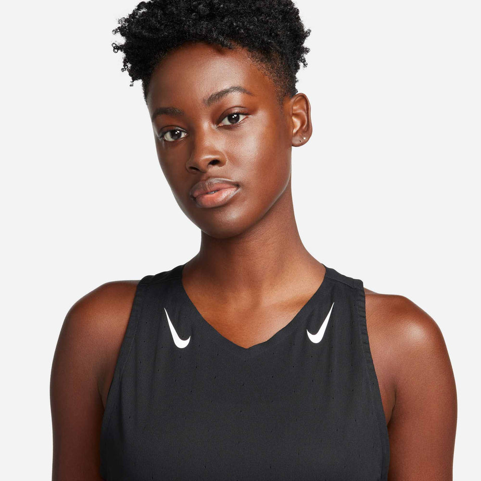 Front view of a model wearing a Nike Women's AeroSwift Dri-FIT ADV Running Singlet in the Black/White colourway. Upper part of singlet can be seen in the image. (8185995428002)