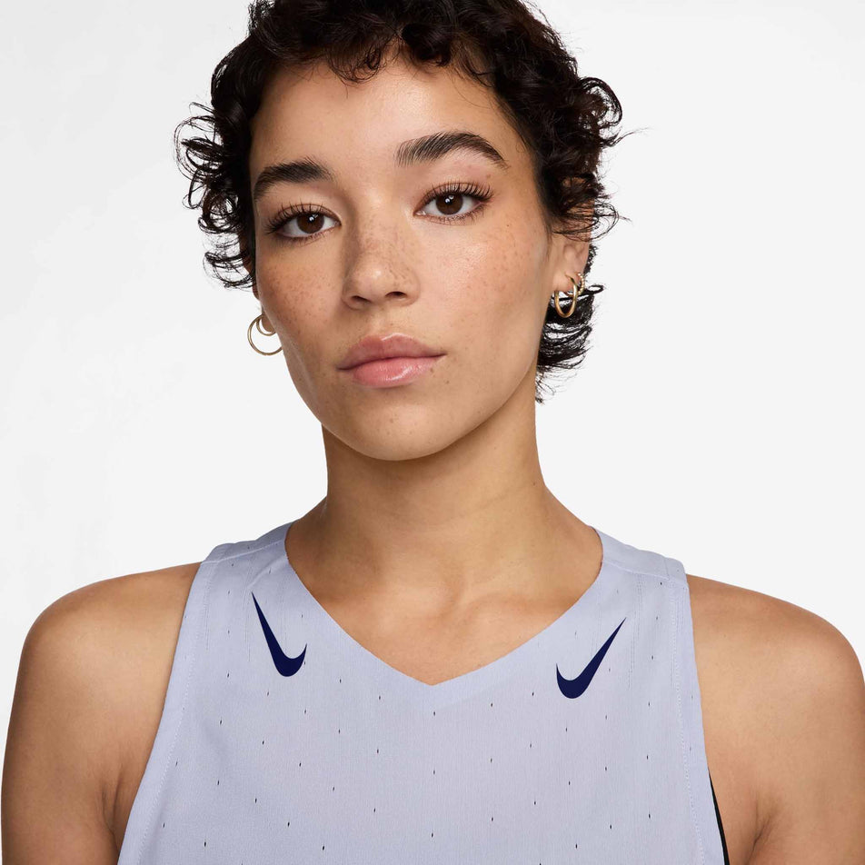 Close-up front view of the upper part of the Nike Women's AeroSwift Dri-FIT ADV Running Singlet in the Ghost/Blue Void colourway. Top is being worn by a model. (8620116344994)