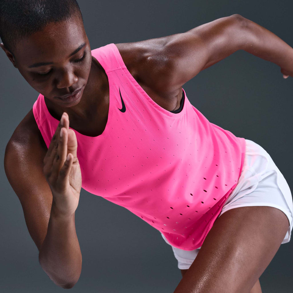 Angled view of a model wearing the Nike Women's AeroSwift Dri-FIT ADV Running Singlet in the Hyper Pink/Black colourway. (8692847444130)