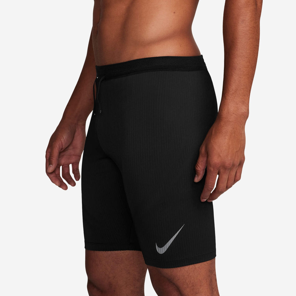 Side view of a model wearing a pair of Nike Men's AeroSwift Dri-FIT ADV Running 1/2-Length Tights in the Black/Summit White colourway (8140202803362)