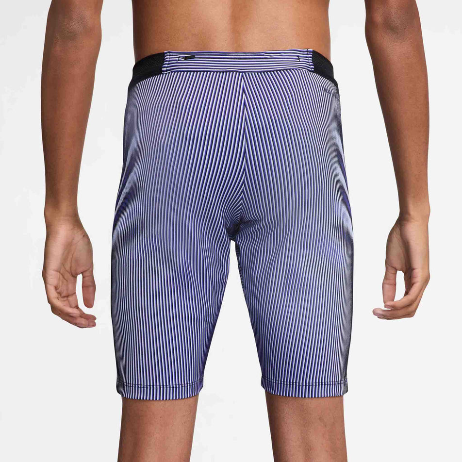 Back view of a model wearing the Nike Men's AeroSwift Dri-FIT ADV Running 1/2-Length Tights in the Vivid Purple/Black/Reflective colourway. (8692967669922)