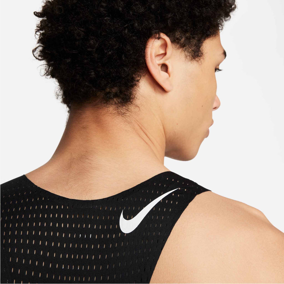 Close-up back view of a model wearing a Nike Men's AeroSwift Dri-FIT ADV Running Singlet in the Black/Summit White colourway. Only the upper part of the singlet can be seen in the image. (8393096462498)