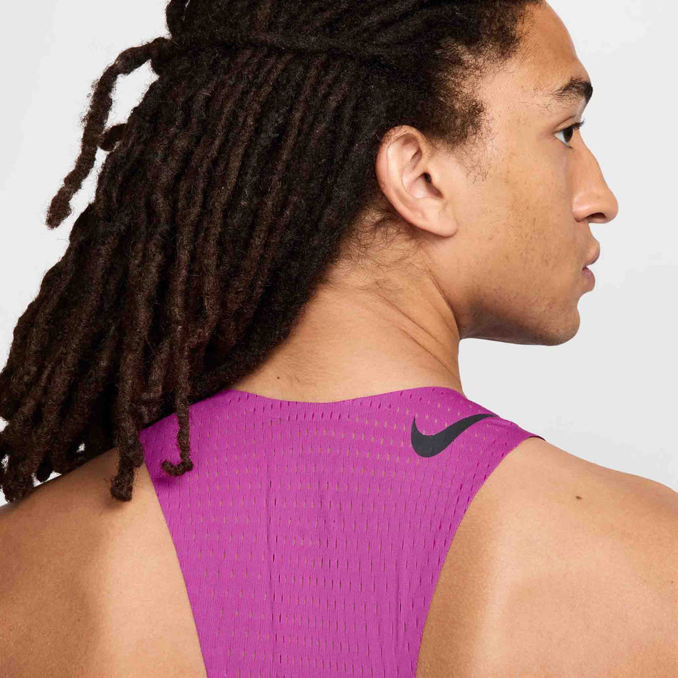 Close-up back view of a model wearing a Nike Men's AeroSwift Dri-FIT ADV Running Singlet in the Hot Fuchsia/Black colourway. Only the upper part of the singlet can be seen in the image. (8497704173730)