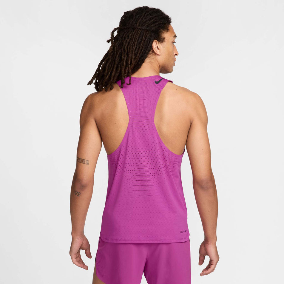 Back view of a model wearing a Nike Men's AeroSwift Dri-FIT ADV Running Singlet in the Hot Fuchsia/Black colourway. Model is also wearing Nike shorts. (8497704173730)
