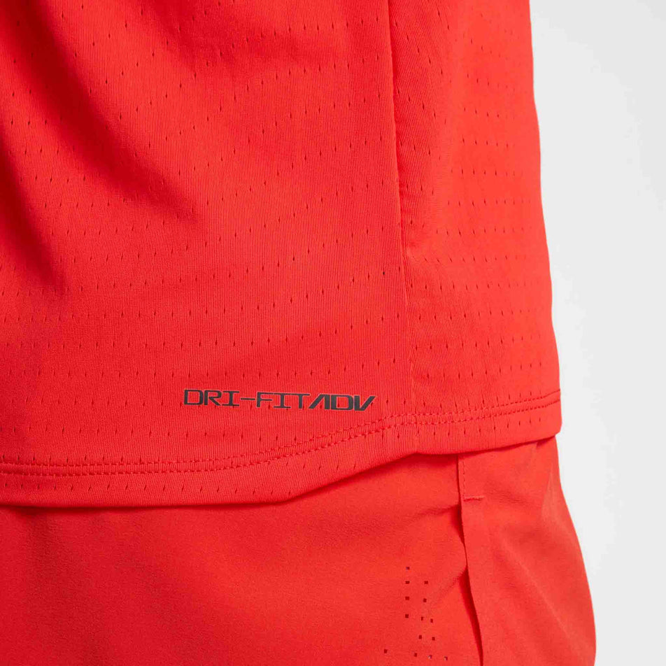 Close up view of the Dri-FIT ADV branding on the Nike Men's AeroSwift Dri-FIT ADV Running Singlet in the Light Crimson/Black colourway. (8571124056226)