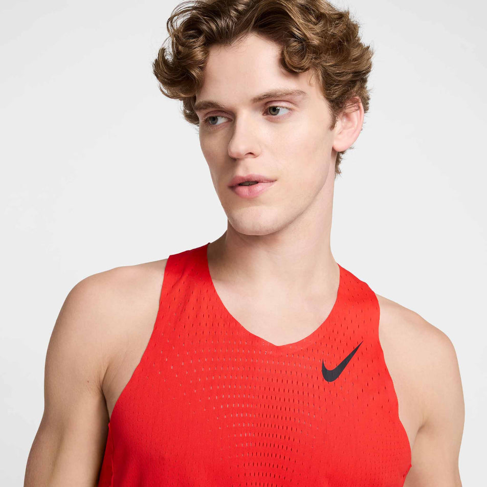 Front view of a model wearing the Nike Men's AeroSwift Dri-FIT ADV Running Singlet in the Light Crimson/Black colourway. (8571124056226)