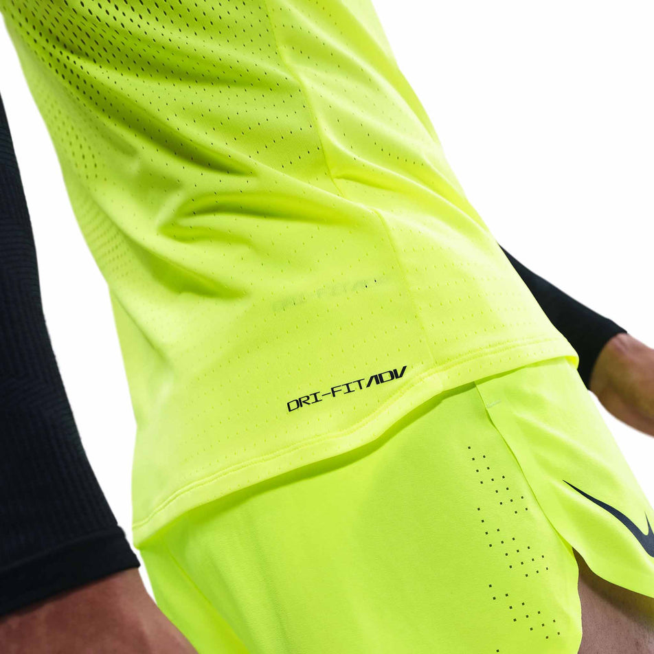 Close-up view of the Dri-FIT ADV branding on the Nike Men's AeroSwift Dri-FIT ADV Running Singlet in the Volt/Black colourway. (8778164699298)