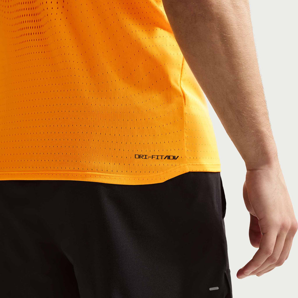 Close-up view of the Dri-FIT ADV branding on the Nike Men's AeroSwift Dri-FIT ADV Running Singlet in the Laser Orange/Black colourway.